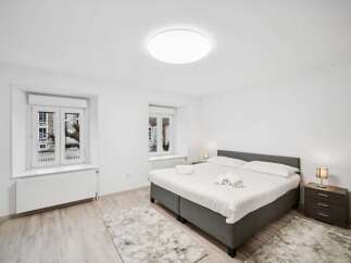 Experience comfort and style in this beautifully appointed bedroom, featuring a plush king-sized bed with crisp white linens and neatly folded towels.