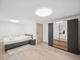 Experience modern comfort in this beautifully appointed bedroom, featuring a plush bed with crisp white linens and convenient bedside tables.