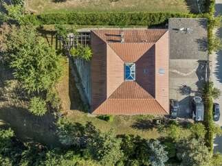 Discover this stunning property featuring a modern home with a distinctive pyramid-shaped roof and a central skylight, perfect for natural illumination.