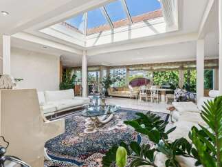 Experience luxurious living in this stunning sun-drenched room, featuring a magnificent glass ceiling that floods the space with natural light.