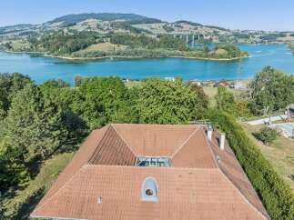 Experience breathtaking panoramic views of a serene lake and rolling hills from this exceptional property.