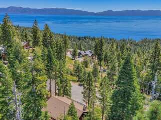 Experience breathtaking lake views from this stunning mountain home, nestled amongst towering pine trees.