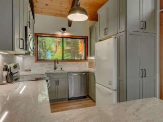 Experience the charm of this mountain kitchen, featuring sleek grey cabinetry and a stunning granite countertop.