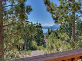 Experience breathtaking lake and mountain views from this stunning property, nestled amidst tall pine trees.