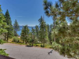 Experience breathtaking lake views from this stunning property, nestled amidst tall pine trees.