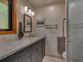 This modern bathroom features a sleek vanity with a granite countertop and ample storage.