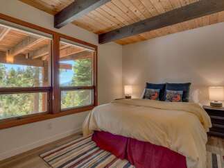 Experience breathtaking mountain views from this serene bedroom, featuring expansive windows that bring the outdoors in.