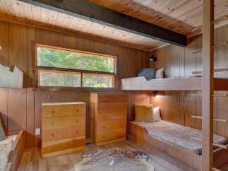 This charming cabin bedroom features a cozy bunk bed setup, perfect for family or guests.