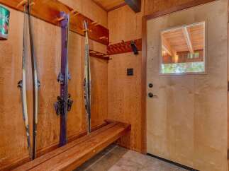 This charming entryway features a convenient ski rack and a rustic wooden bench, perfect for gearing up for outdoor adventures.
