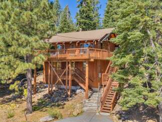 Nestled amidst towering pine trees, this charming wooden home offers a serene mountain retreat.