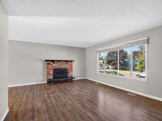 Experience comfort and style in this inviting living room, featuring a charming brick fireplace as the focal point.
