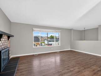 Step into this inviting living space featuring a cozy brick fireplace, perfect for gathering on cooler evenings.