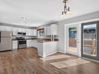 Discover this charming kitchen featuring white cabinetry and a functional layout, perfect for everyday cooking.