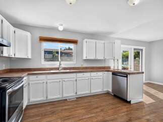 Discover this charming kitchen featuring crisp white cabinetry and warm, wood-toned countertops.