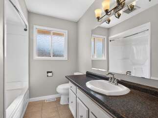This bright and airy bathroom features a spacious bathtub and a separate shower stall, perfect for relaxation.