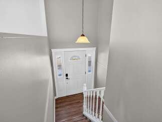 Step into a welcoming entryway featuring a classic white door with decorative glass sidelights and a transom window.