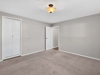 This spacious bedroom features a large closet with bi-fold doors, perfect for ample storage.