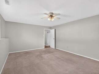 This spacious room features neutral carpeting and light gray walls, creating a serene and versatile atmosphere.