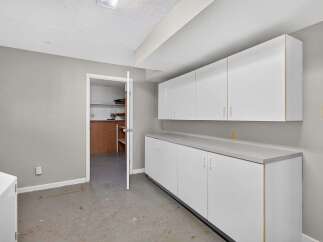 Discover ample storage solutions in this versatile space, featuring a long countertop with upper and lower cabinets.