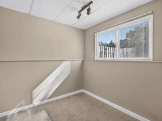 This room features a large window with blinds, allowing natural light to fill the space.