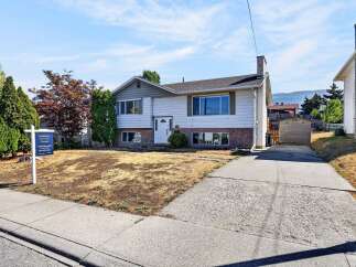 Charming split-level home with a welcoming facade, featuring a white front door and large windows for ample natural light.