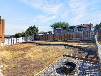 This spacious backyard offers a blank canvas for your outdoor living dreams, featuring a large, dry lawn area perfect for gardening or play.