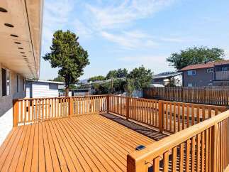 Step outside onto this expansive wooden deck, perfect for entertaining or enjoying a quiet afternoon.