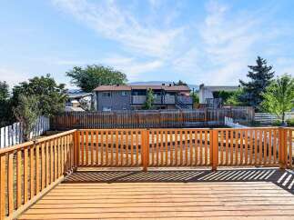 Enjoy outdoor living on this spacious wooden deck, perfect for entertaining or relaxing.