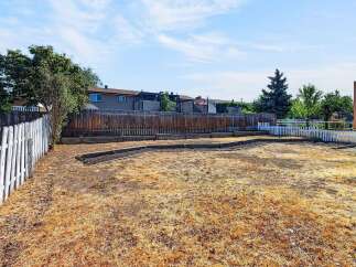 Discover the potential of this spacious backyard, perfect for gardening enthusiasts and outdoor entertaining.