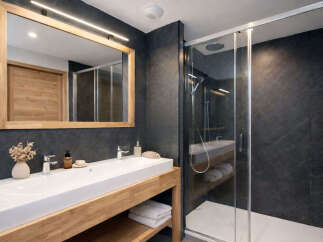 Experience modern luxury in this stunning bathroom featuring a sleek, long white vanity with a wooden base.