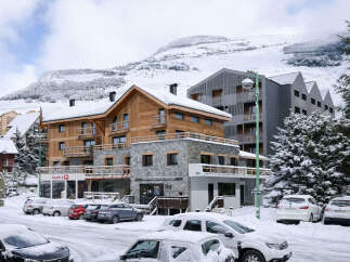 Experience the charm of a winter wonderland with this stunning property nestled in a snowy mountain landscape.