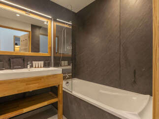 Experience modern luxury in this beautifully appointed bathroom, featuring a sleek vanity with a spacious sink and ample storage.