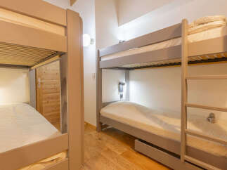 This charming bedroom features two sets of bunk beds, perfect for accommodating families or groups.