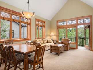 Experience comfortable living in this inviting space, featuring a spacious dining area with a wooden table and chairs, perfect for family meals.