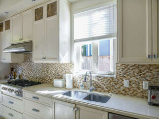 This modern kitchen boasts a sleek stainless steel range and a double basin sink, perfect for any home chef.