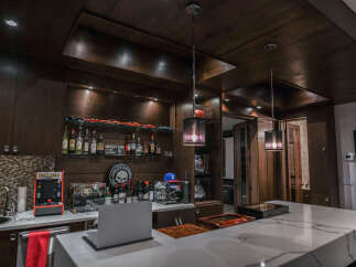 Experience ultimate entertainment in this custom-built bar and game room, featuring a Pac-Man arcade machine and a stunning collection of sports memorabilia.