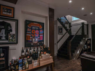 Showcasing a sophisticated entertainment area, this home features a dedicated display for sports memorabilia, including framed jerseys of legendary athletes like Gretzky and Jackson.