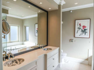 Indulge in luxury with this stunning master bathroom featuring a spacious double vanity with elegant floral-patterned sinks and polished chrome fixtures.