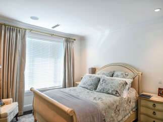 Experience comfort and style in this beautifully appointed bedroom, featuring elegant floral bedding and plush accent pillows.