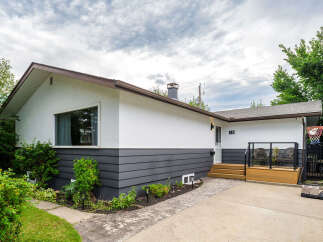 Discover this charming home featuring a modern exterior with crisp white stucco and dark gray siding.