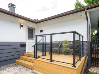 Step onto the inviting wooden deck, complete with a modern glass railing, perfect for enjoying your morning coffee.