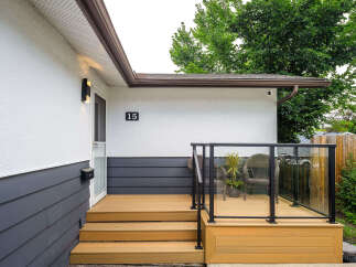 Welcome to this charming home featuring a modern deck with glass railings, perfect for outdoor relaxation and entertaining.