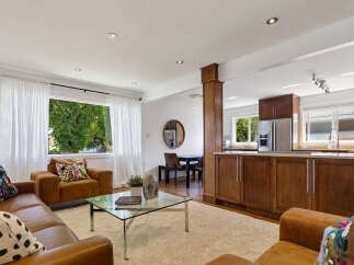 Experience open-concept living in this beautifully appointed home, featuring a spacious living area seamlessly flowing into a modern kitchen.