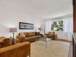 Step into this inviting living room, featuring a plush tan sectional sofa and a matching armchair, perfect for cozy gatherings.