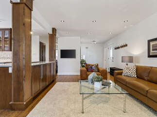 Step into this inviting living space featuring a warm leather sofa and a cozy armchair, perfect for relaxation.