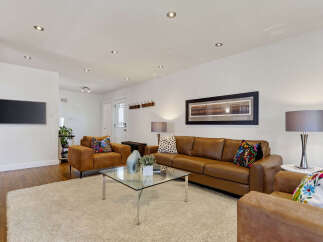 Step into this inviting living room, featuring a plush cream rug and a sleek glass coffee table perfect for gatherings.