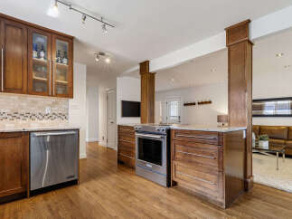 This stunning kitchen features rich wooden cabinetry and a sleek stainless steel dishwasher.