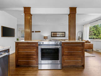 This spacious kitchen features a sleek stainless steel range set against rich wooden cabinetry, perfect for the home chef.