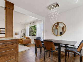 Experience modern living in this stunning dining area, featuring a sleek dark wood table complemented by stylish chairs with wood accents.