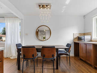 This dining area features a stylish dark wood dining table with four chairs, two of which have warm wood accents.